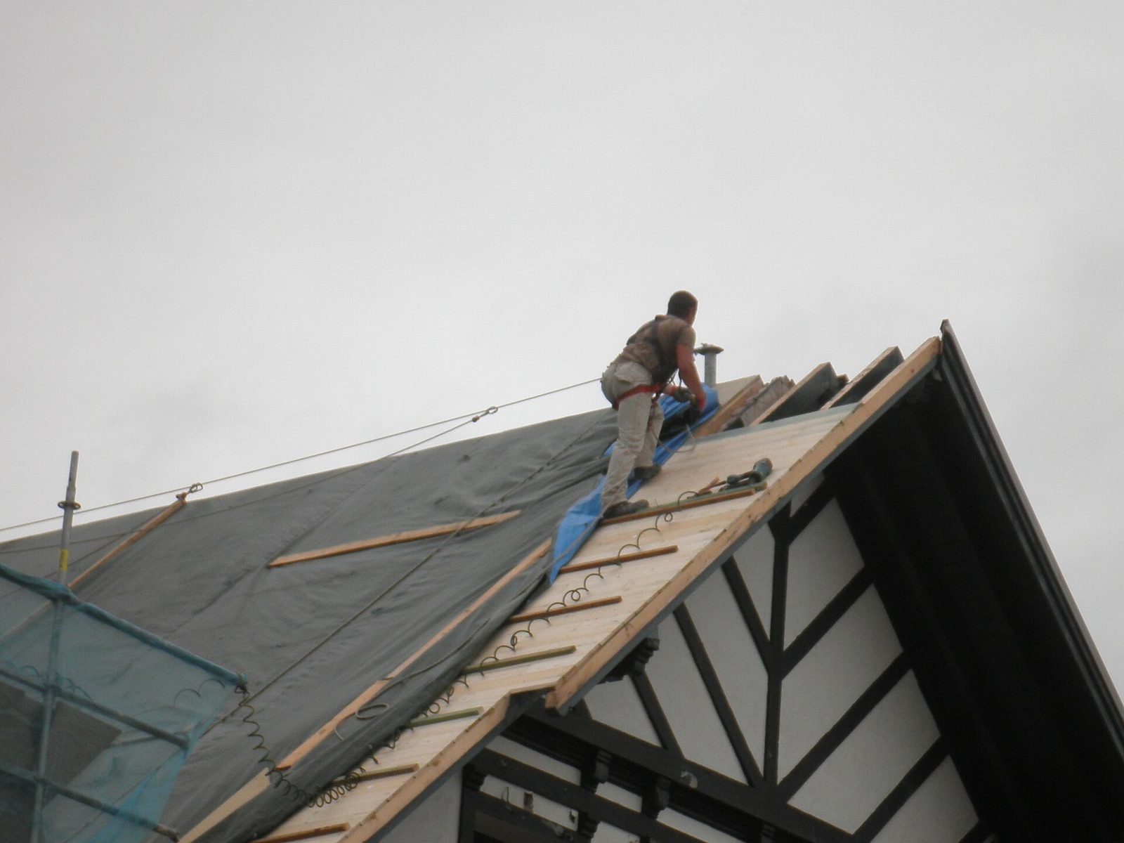 Dakwerker op een hellend dak tijdens renovatiewerken